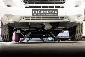 Vooraanzicht van een witte camper die strak waterpas staat op een automatisch Campexx levelsysteem.