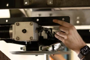 Een monteur van HTW Camperservice installeert vakkundig de op maat gemaakte adapters van het levelsysteem onder de camper.