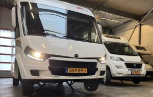 Meerdere campers, waaronder een Malibu en een Fiat Ducato, tijdens de inbouw en het afstellen van een automatisch levelsysteem in onze werkplaats.